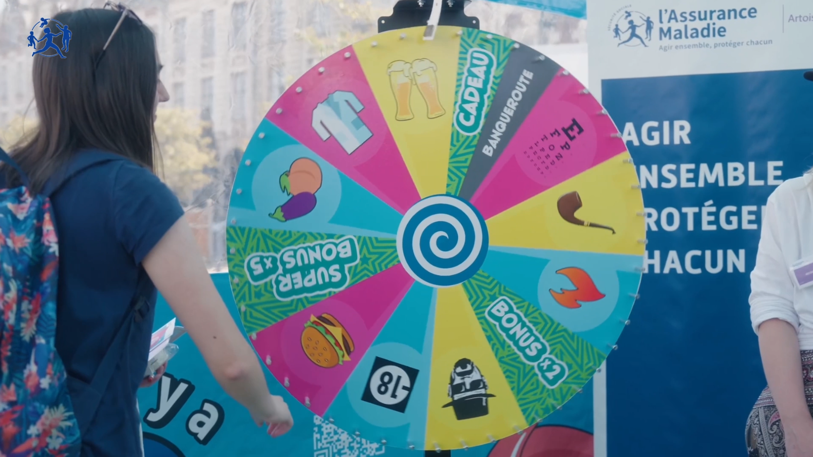 Photo d'une animation incluse dans le roadshow Mes tips santé. Une jeune femme fait tourner une roue colorée pour participer à un jeu.